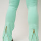 Mint green leggings with gold zippers on a white background